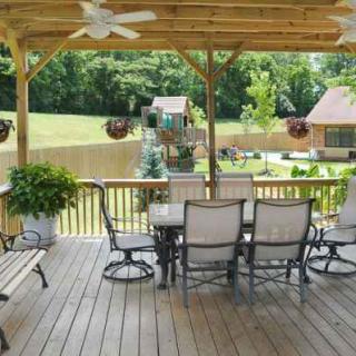 A cozy outdoor patio with seating and a view of the backyard.