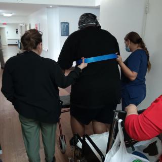 Healthcare professionals assist a patient in rehabilitation exercises.