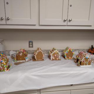 A display of beautifully decorated gingerbread houses arranged on a table in a kitchen.