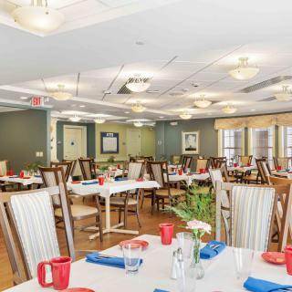A brightly lit dining room with neatly arranged tables and chairs, ready for guests.