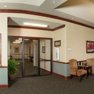 A well-lit hallway with a small seating area and decorative elements.
