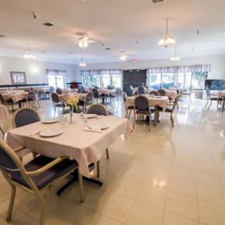 An empty restaurant dining room with neatly arranged tables and chairs.