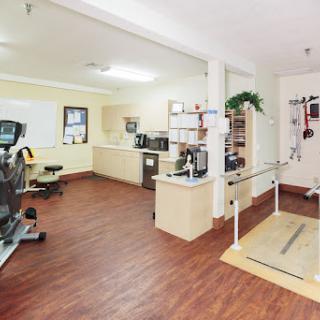 A well-equipped rehabilitation room featuring exercise equipment and therapy aids, designed for physical therapy sessions.