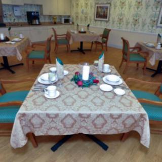 A neatly set table in a dining room with elegant decor and multiple chairs.