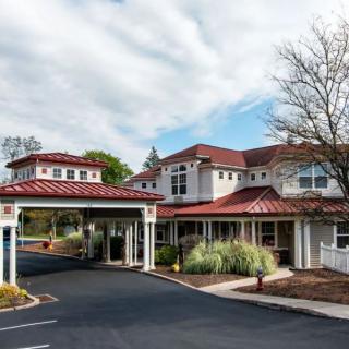 A scenic view of a hotel building with a covered entrance and surrounding landscape.