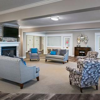 A spacious and elegantly decorated living room featuring a fireplace, comfortable sofas, armchairs, and stylish decor.