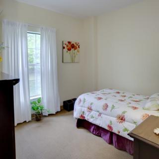 A cozy bedroom with a bed, window, and decorative elements.