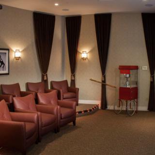 A cozy home theater setup with leather chairs and a popcorn machine.
