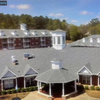 Aerial view of a large building complex with a central courtyard and gazebo.