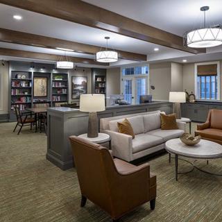A modern living room with comfortable seating, bookshelves, and elegant lighting.