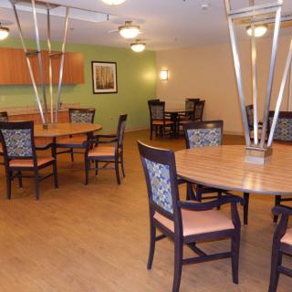 A modern dining room with multiple tables and chairs, featuring stylish lighting and decor.