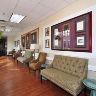 A well-decorated waiting room featuring comfortable seating and framed art on the walls.
