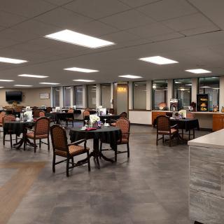 An empty dining area with tables and chairs arranged in a well-lit room.