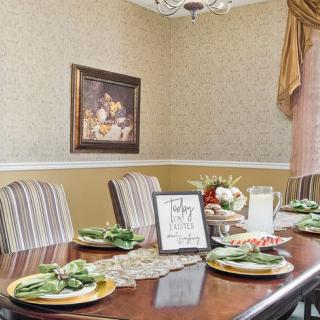 A well-decorated dining room with a formal table setting and elegant decor.