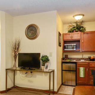 A cozy living space with a small kitchenette and a television.
