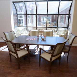 A well-lit conference room featuring a large table surrounded by chairs, ideal for meetings and collaborations.