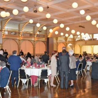 A formal indoor banquet with people gathered around tables.
