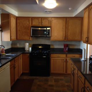 A kitchen featuring wooden cabinets and black appliances.