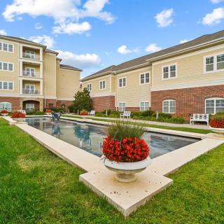 A well-maintained apartment complex with a central swimming pool and landscaped garden.