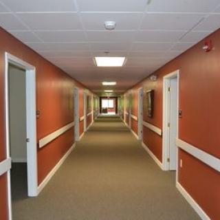 A long, empty hallway with brown walls and several doors.