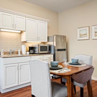 A cozy kitchen and dining area with modern appliances and a neatly set table.