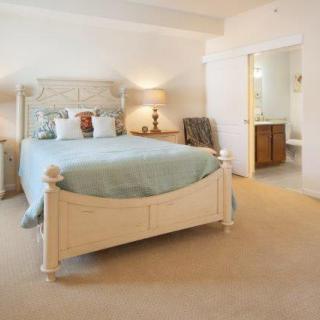 A cozy and well-decorated bedroom with a large bed, stylish furniture, and an adjoining bathroom.