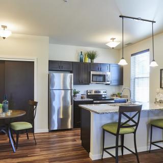 A modern kitchen interior with stainless steel appliances and a cozy dining area.