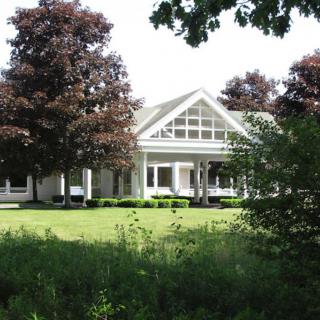 A charming house surrounded by lush greenery and trees.