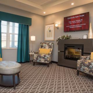 A cozy living room with a fireplace, patterned armchairs, and modern decor.
