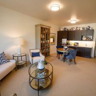 A cozy, modern open-concept living room with a kitchenette and dining area.