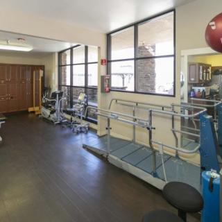 A gym room equipped with various exercise machines and weights.