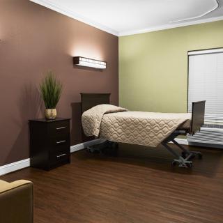 A modern, minimalist room with a hospital bed and simple decor.