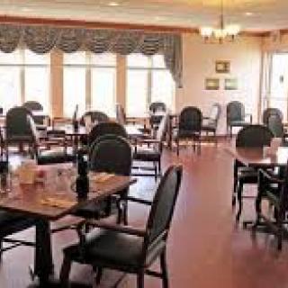 An empty dining room with neatly arranged tables and chairs.