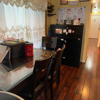 A cozy home office setup with a laptop on a desk and wooden floors.