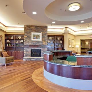 A welcoming lobby featuring a modern design with wooden flooring and a cozy fireplace.
