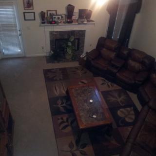 A cozy living room with a sofa set, coffee table, and a fireplace.