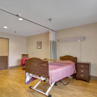 An empty hospital room with a medical bed and bedside table.