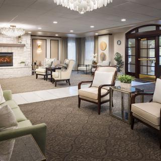 A cozy living room featuring elegant furniture, a fireplace, and a chandelier.