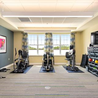 A well-equipped gym with exercise machines and weights.