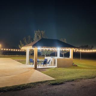 A cozy gazebo illuminated by string lights on a quiet night.