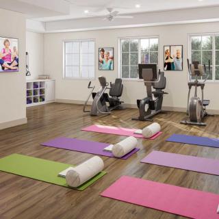 A well-lit gym with yoga mats and exercise bikes, ready for workout sessions.