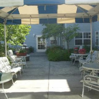 A shaded outdoor patio area with seating and tables.
