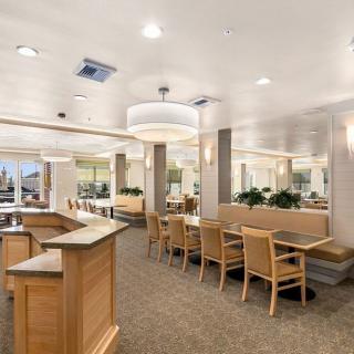 A modern dining area with wooden furniture and bright lighting.