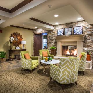 A cozy and modern lobby with comfortable seating around a fireplace.