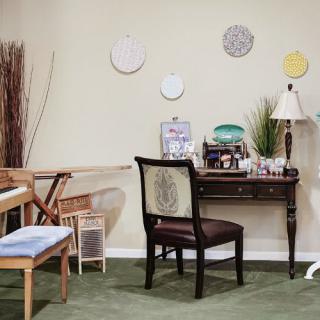 A cozy home office setup with a desk, chair, and decorative wall plates.