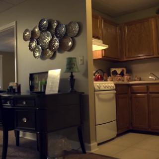 A cozy interior featuring a kitchen area and a decorated living space with wall art.