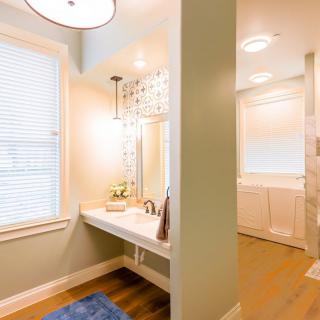 A modern bathroom with stylish lighting and wooden flooring.