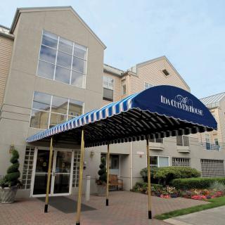 The entrance of a hotel with a blue awning.
