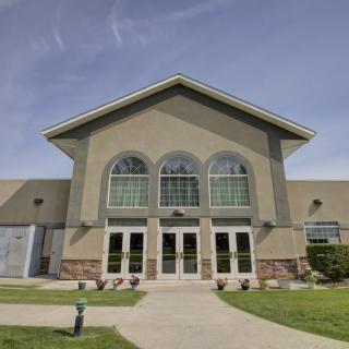 A modern building with large arched windows under a clear blue sky.