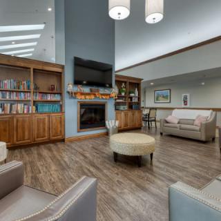A modern and cozy living room with a fireplace, bookshelves, and comfortable seating.